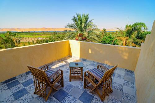 a balcony with chairs and a table and a view of the desert at Tache Boutique Hotel Fayoum in Fayoum