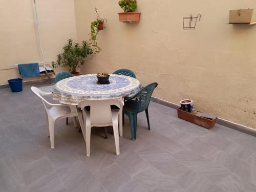 une table et des chaises assises sur une terrasse dans l'établissement Dynesty B&B, à Birżebbuġa