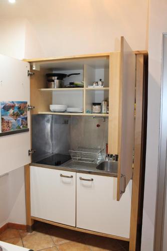 Una cocina con gabinetes blancos y un fregadero. en House of Vera, en La Spezia
