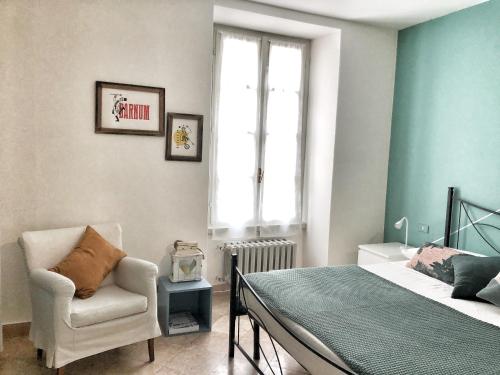 1 dormitorio con 1 cama, 1 silla y 1 ventana en Bergamondo, en Bérgamo