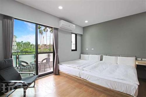 1 dormitorio con 1 cama grande y balcón en Ark stay方舟文旅山嵐新館溜滑梯商務民宿 en Jiji