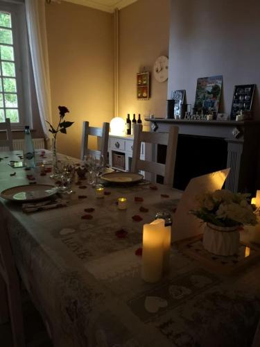 - une table à manger avec des bougies et des fleurs dans l'établissement La Bohème, à Francastel