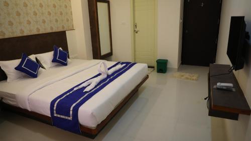 a bedroom with a large bed with blue and white sheets at DC comforts in Chikmagalūr