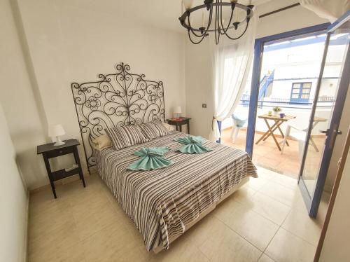a bedroom with a large bed with a chandelier at VolKKanrentals Casa Machín in Famara