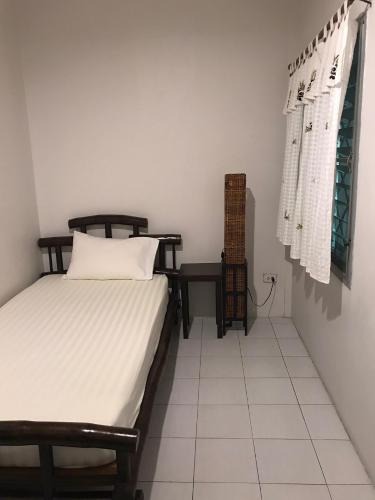 a bedroom with a bed and a table in a room at Lamphuhouse Bangkok in Bangkok