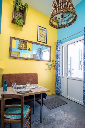 une salle à manger avec des murs jaunes, une table et des chaises dans l'établissement Gîte La Périssoire - place de parking incluse, à Étretat