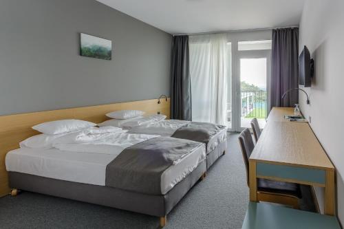 Un pat sau paturi într-o cameră la Rákóczi Hotel, Tábor és Rendezvényközpont