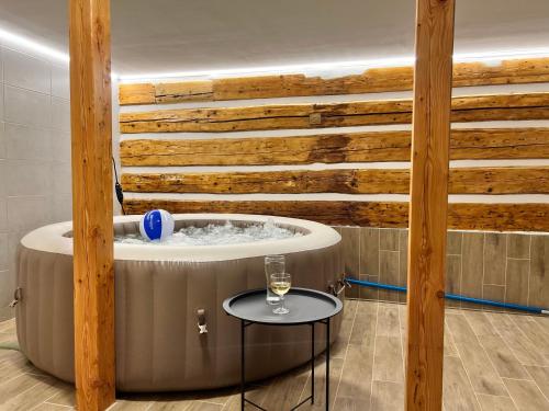 a hot tub in a room with a wooden wall at Pardubické boudy in Janske Lazne