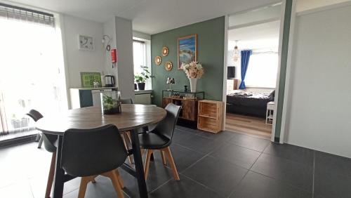 a dining room with a table and chairs and a bedroom at Breakfast at Carin’s in Vlissingen