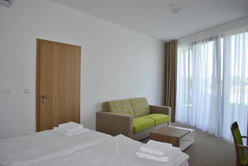 pokój hotelowy z łóżkiem i kanapą w obiekcie Hotel Golf Jezera w mieście Ostrožská Nová Ves