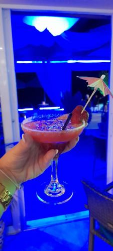 a person holding a drink in a martini glass at San Georgio Hotel in Tsoútsouros