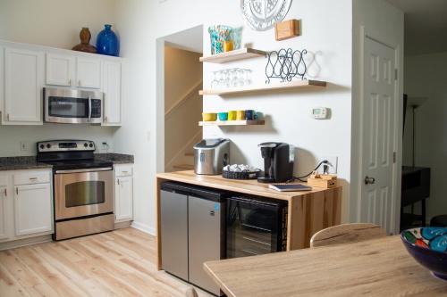 a kitchen with white cabinets and a wooden counter top at True North - A Beach & Boat Lover's Dream in Carolina Beach
