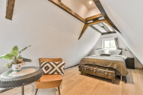 een slaapkamer met een bed, een tafel en een stoel bij Herengracht Private room with canal view in Amsterdam