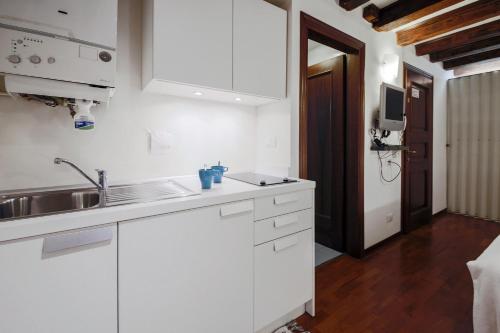 a kitchen with white cabinets and a sink at Wonderful studio Wi-Fi AC in Venice