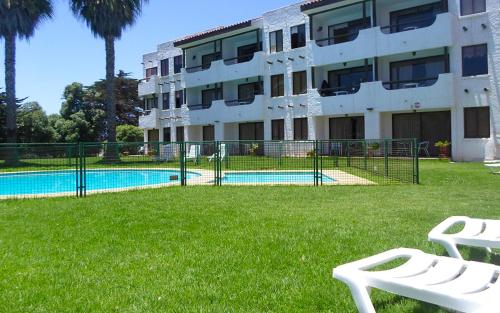um edifício com piscina em frente a um edifício em Apart Hotel Sendero del Sol em La Serena
