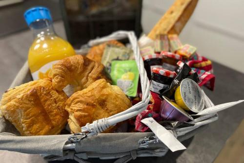 einen Korb mit Essen und einer Flasche Orangensaft in der Unterkunft Séjour Romantique Jacuzzi intérieur Privé in Le Vigan