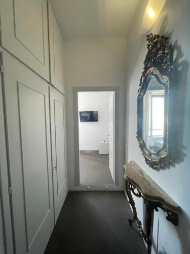 a hallway with a mirror on the wall and a chair at Villino Saraceno Rostain in Borgio Verezzi