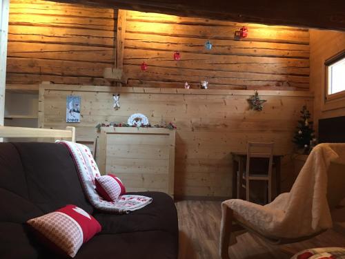 - un salon avec des murs en bois et un canapé dans l'établissement Appartement Le Pontet Areches Beaufort, à Arêches