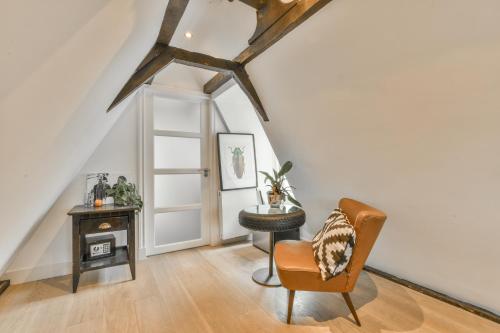 an attic room with a chair and a table at Herengracht Private room with canal view in Amsterdam