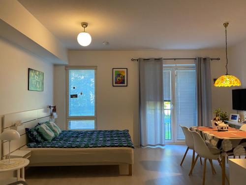 1 dormitorio con 1 cama y comedor en Stylished and Bright studio apartment en Helsinki