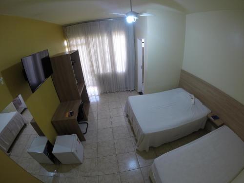 Habitación pequeña con cama y TV. en Hotel Carreiro Inhapim, en Inhapim