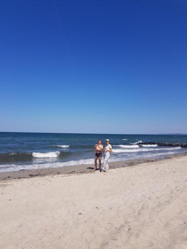two men standing on a beach near the ocean at Hamburg Niendorf-Suite in Hamburg