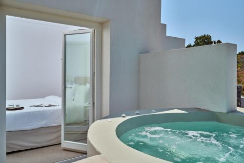 a bath tub in a room with a bedroom at Lilium Homes in Karterados