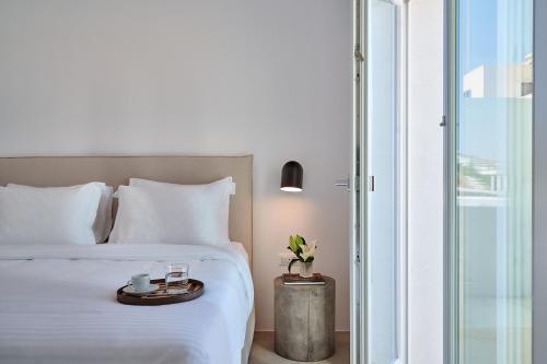 a bedroom with a white bed and a glass door at Lilium Homes in Karterados