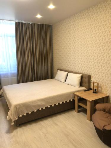 ein Hotelzimmer mit einem Bett und einem Tisch in der Unterkunft Квартира в Вышгороде для души in Wyschhorod