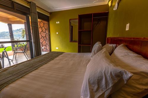 a large bed in a room with a window at Bunyonyi Overland Resort in Kabale
