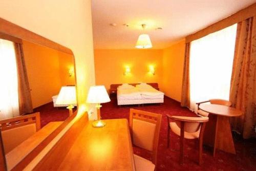 a hotel room with a bed and a table and chairs at OKRĄGLAK Residence Sosnowiec in Sosnowiec