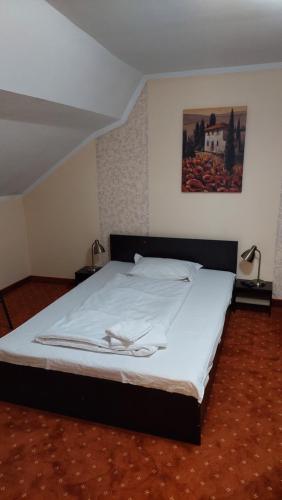 Un dormitorio con una cama grande con sábanas blancas. en Casa Livia, en Oradea