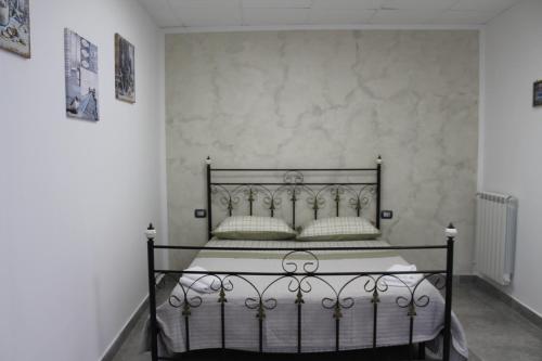 1 Schlafzimmer mit einem schwarzen Bett und 2 Kissen in der Unterkunft riccia, frolla e babbà in Neapel
