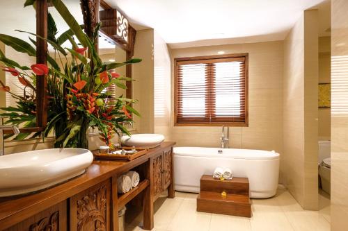 uma casa de banho com uma banheira e um lavatório e uma banheira em The Grand Hill Resort-Hotel em Puncak