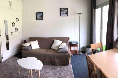 a living room with a couch and a table at Le Skidoux 2*, au pied des pistes, vue montagne in Gourette