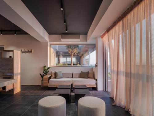 a living room with a couch and two stools at 3 Olive Trees in Anavissos