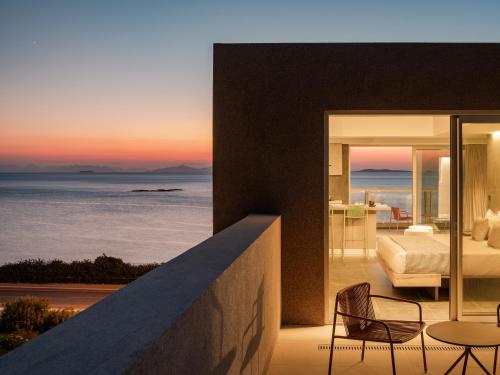 a room with a view of the ocean at sunset at 3 Olive Trees in Anavissos