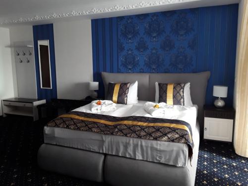 a bedroom with a large bed with a blue wall at Mucha OHG Hotel Sembziner Hof in Klink