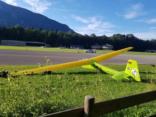 un avión amarillo tirado en la hierba junto a una valla en Haus Wiesenblick, en Oberwössen