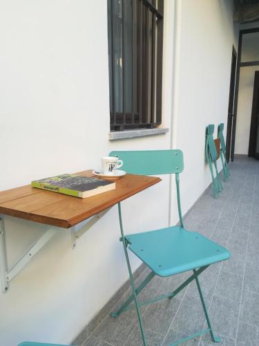 a blue chair and a table with a cup on it at B&B Borgo Vanchiglia in Turin