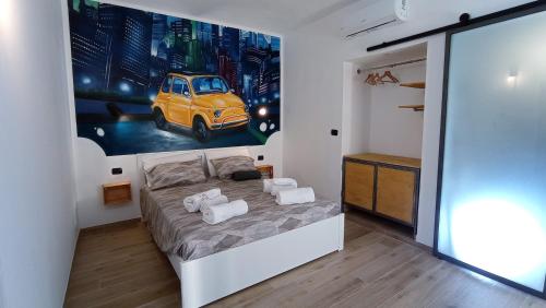 a bedroom with a bed and a painting of a car at B&B Borgo Vanchiglia in Turin