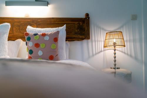 a bedroom with a bed with a pillow and a lamp at Hotel Au Nom De Dieu in Dilsen-Stokkem