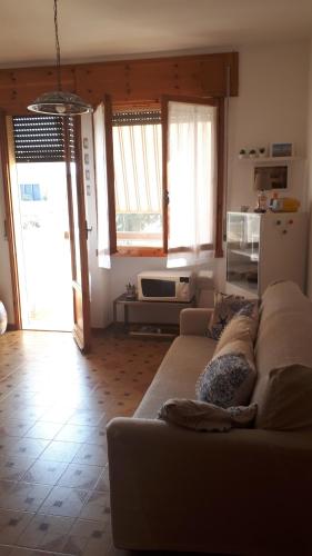 a living room with a couch and a refrigerator at Casabella Sabaudia in Sabaudia