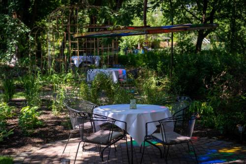 a table and chairs in a garden with a white table cloth at Hotel Au Nom De Dieu in Dilsen-Stokkem