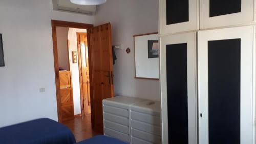um quarto com uma cama, um armário e uma porta em Casabella Sabaudia em Sabaudia