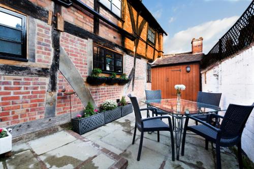 a patio with a table and chairs and a building at "Wesley House" Historic home in town Centre with Parking Options in Shrewsbury