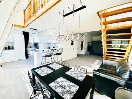 a dining room and kitchen with a table and chairs at Panoramic View PH By The Sea in Palanga