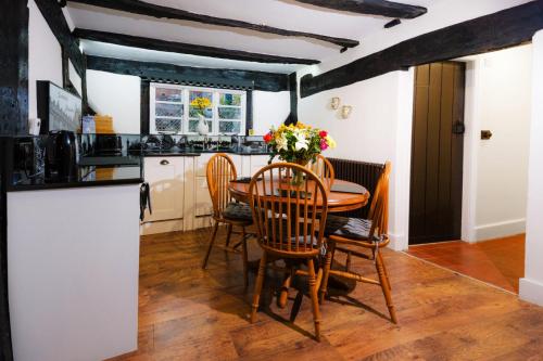 a kitchen with a table and chairs and a counter at "Wesley House" Historic home in town Centre with Parking Options in Shrewsbury