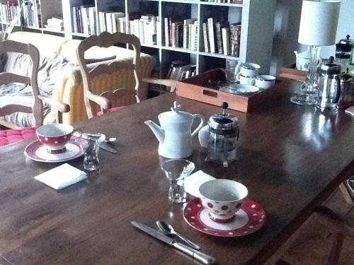 - une table en bois avec un service à thé dans l'établissement Les Trois Maillets, Monument Historique, à Orléans