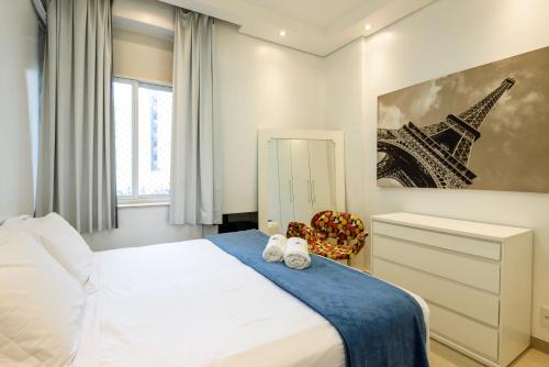 ein Schlafzimmer mit einem Bett und einem Bild des Eiffelturms in der Unterkunft Estilo em Ipanema - Boa localização - VP305 Z2 in Rio de Janeiro